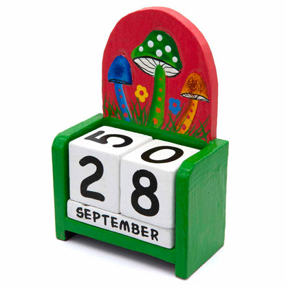 Three-quarter view of green wooden mushroom calendar showing white rotating date blocks, Indonesia