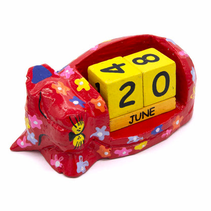 Three-quarter view of red floral sleeping cat calendar with yellow date blocks, Indonesia
