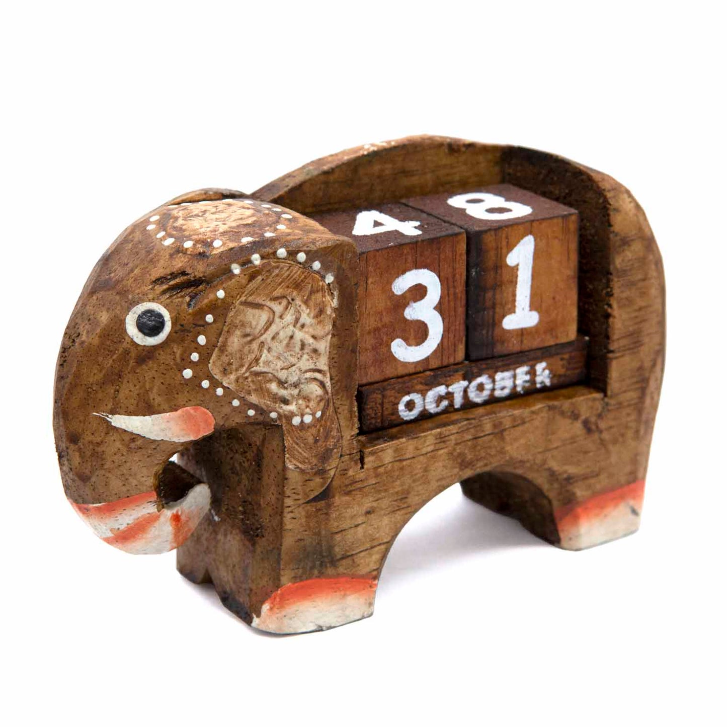 Three-quarter front view of small carved elephant calendar showing relief ear detail and white dot decoration