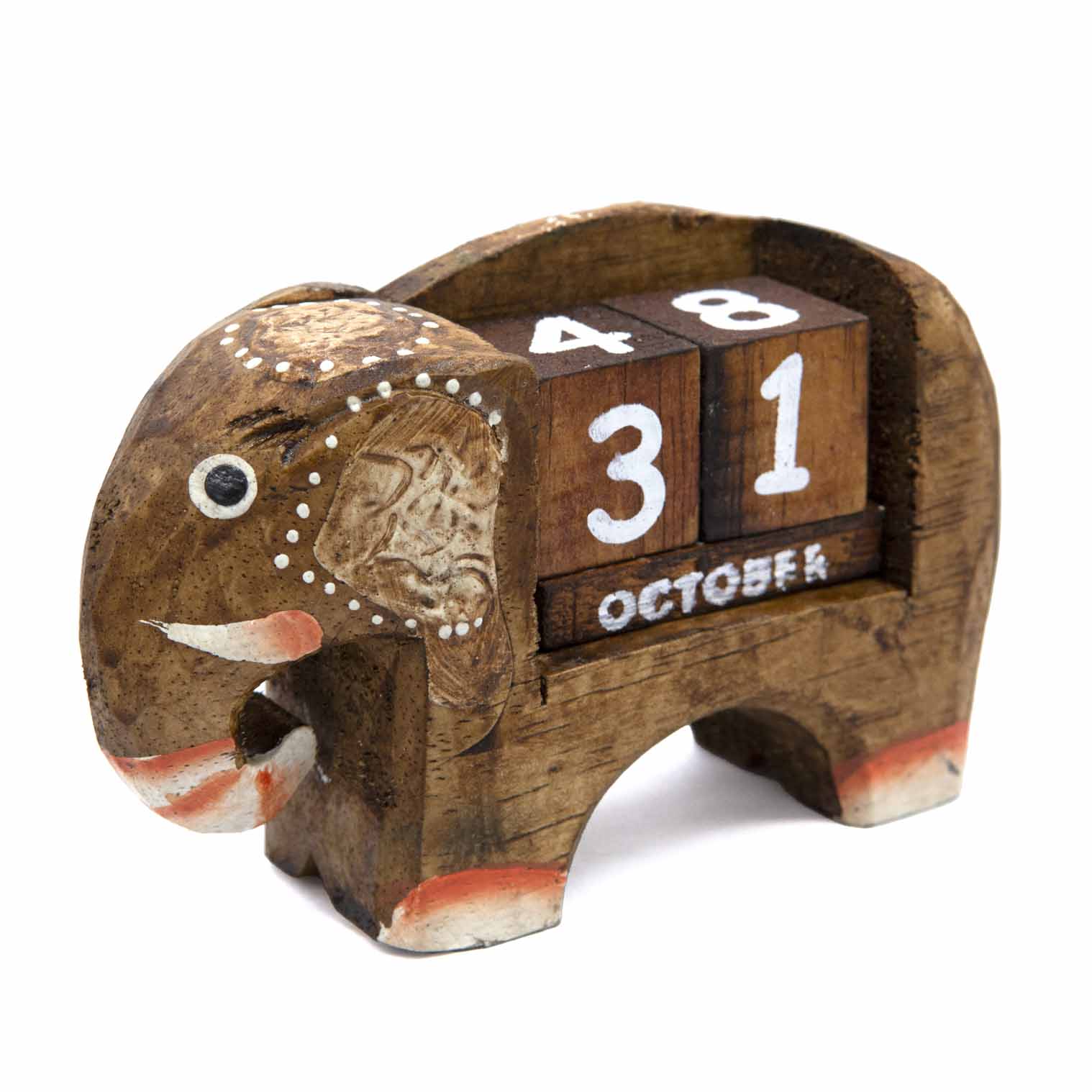 Three-quarter front view of small carved elephant calendar showing relief ear detail and white dot decoration
