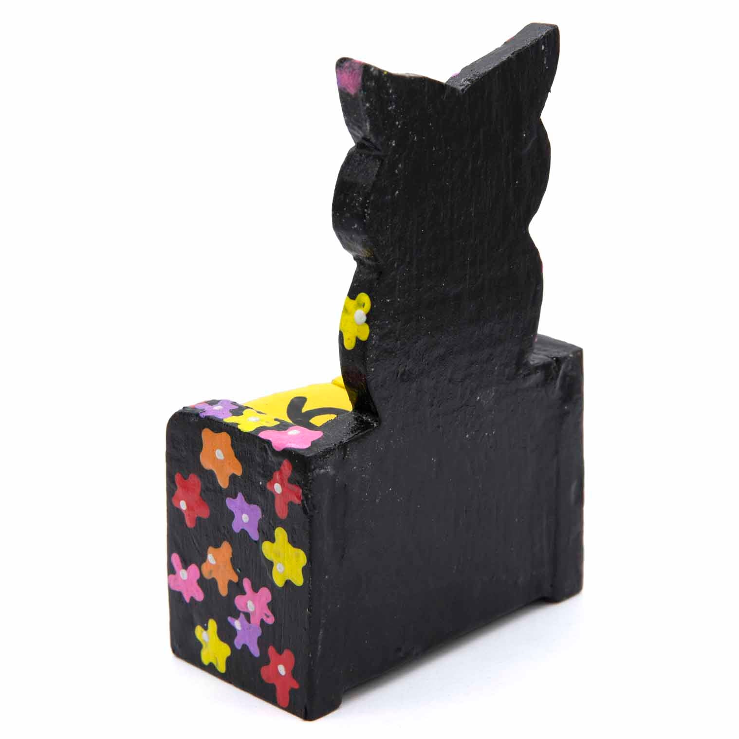Rear view of black painted wooden owl calendar showing plain painted back and flower-covered sides
