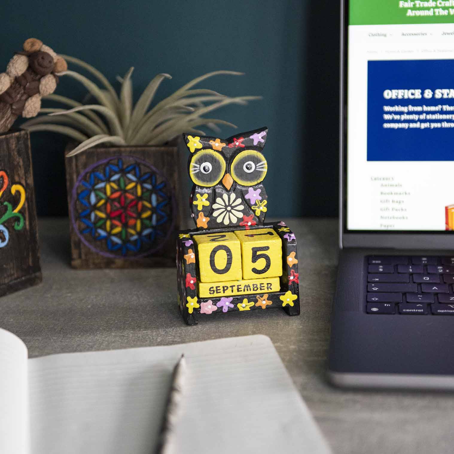 Black painted wooden owl perpetual calendar on a desk showing September date, Indonesia
