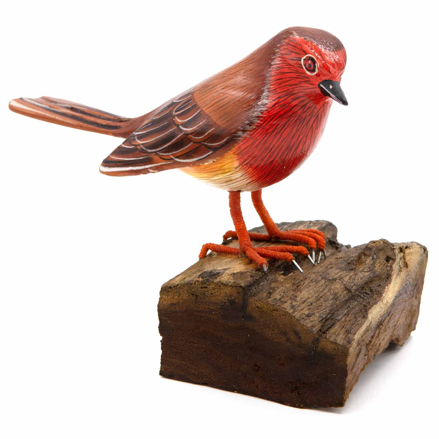 Carved painted robin figurine on rough wood base, red breast and brown wings, side view