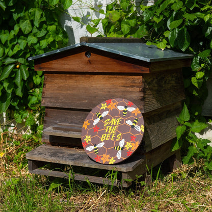 Round Save the Bees wood plaque leaning against a wooden beehive in a garden, Indonesia