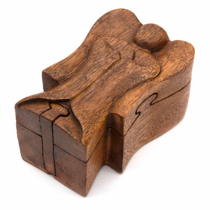 Wooden angel puzzle box closed, showing carved abstract angel form with puzzle joints visible, three-quarter view