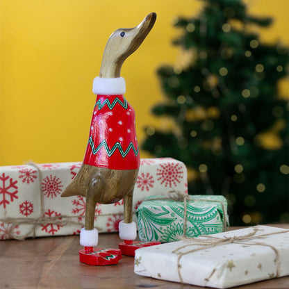 Christmas jumper bamboo root duck in red snowflake jumper with fur collar, photographed with wrapped presents and Christmas t