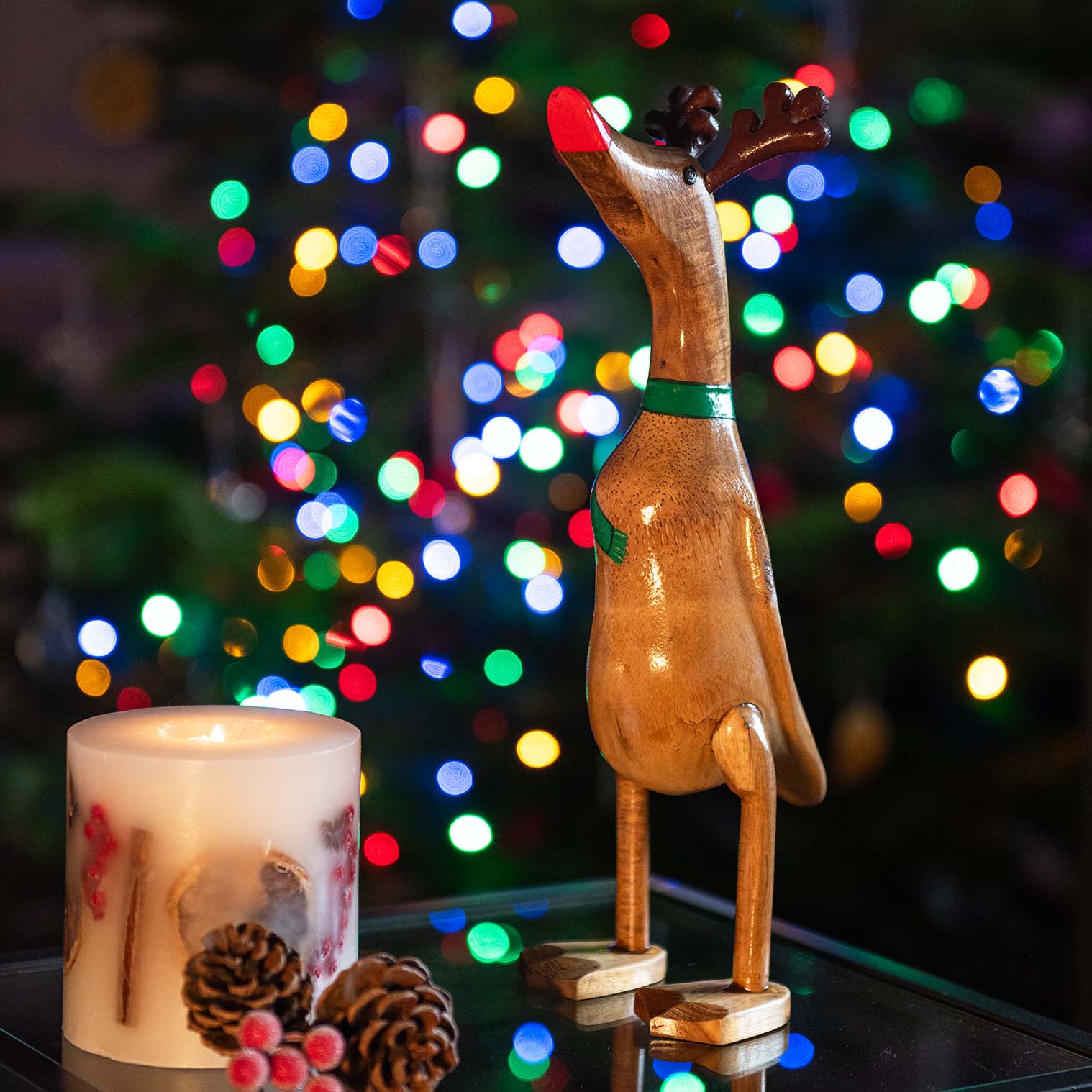 Reindeer bamboo root duck with carved antlers and red bill, photographed against Christmas tree bokeh lights