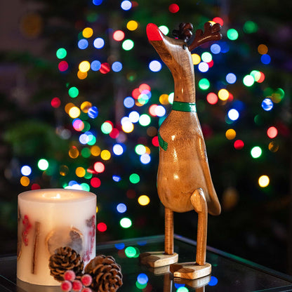 Reindeer bamboo root duck with carved antlers and red bill, photographed against Christmas tree bokeh lights