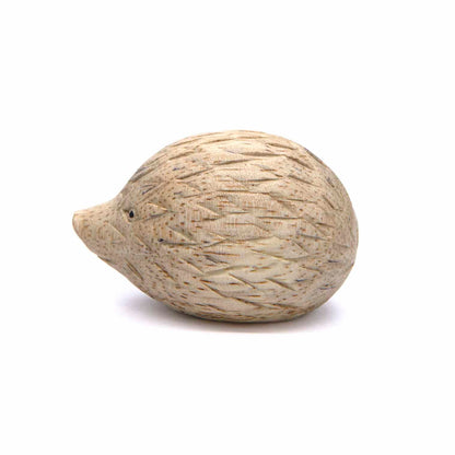 Small carved hedgehog figurine, side view showing diamond-cut spine pattern, pale wood