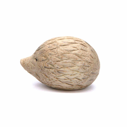 Small carved hedgehog figurine, side view showing diamond-cut spine pattern, pale wood