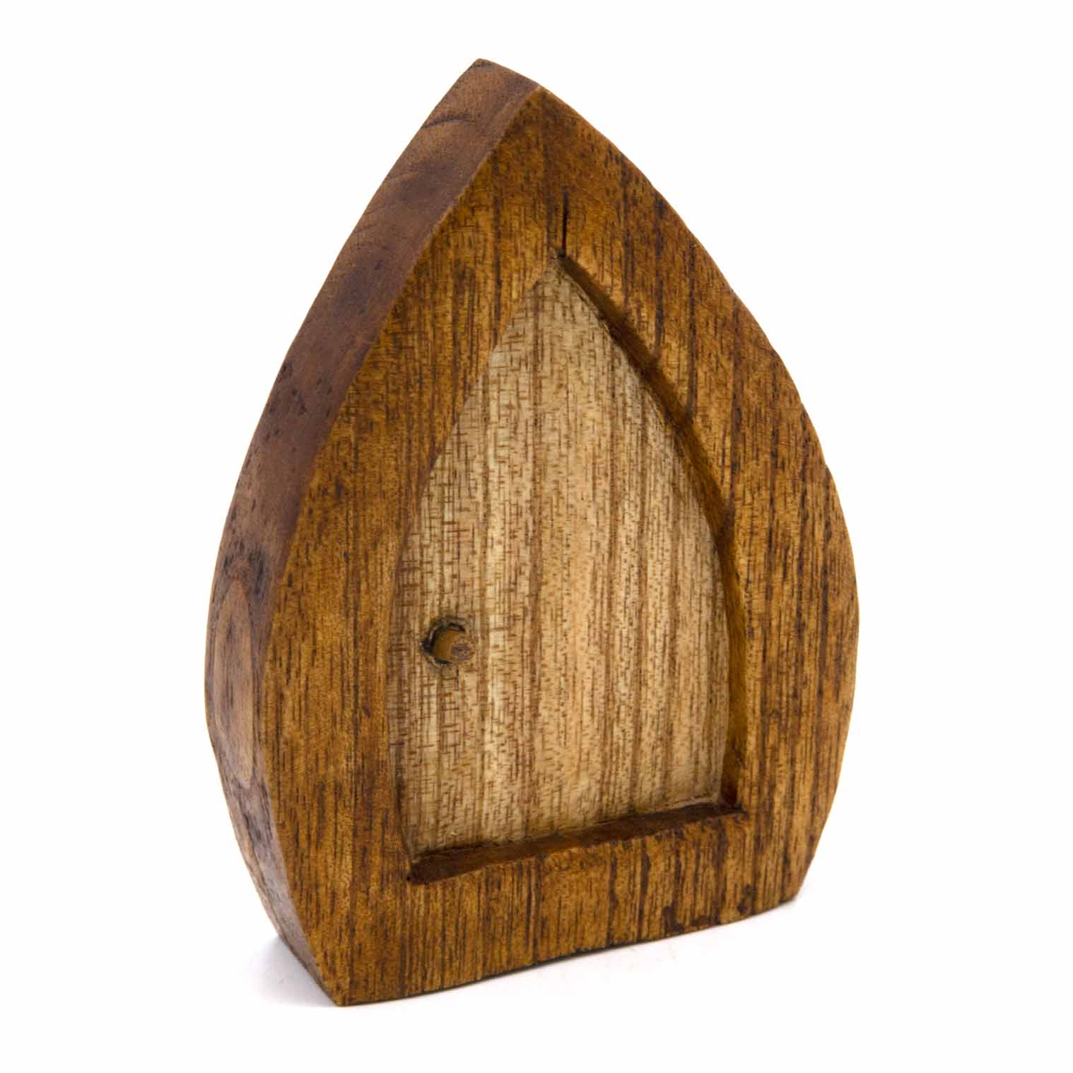 Hand-carved fairy door, three-quarter view showing recessed panel and round knob, amber wood
