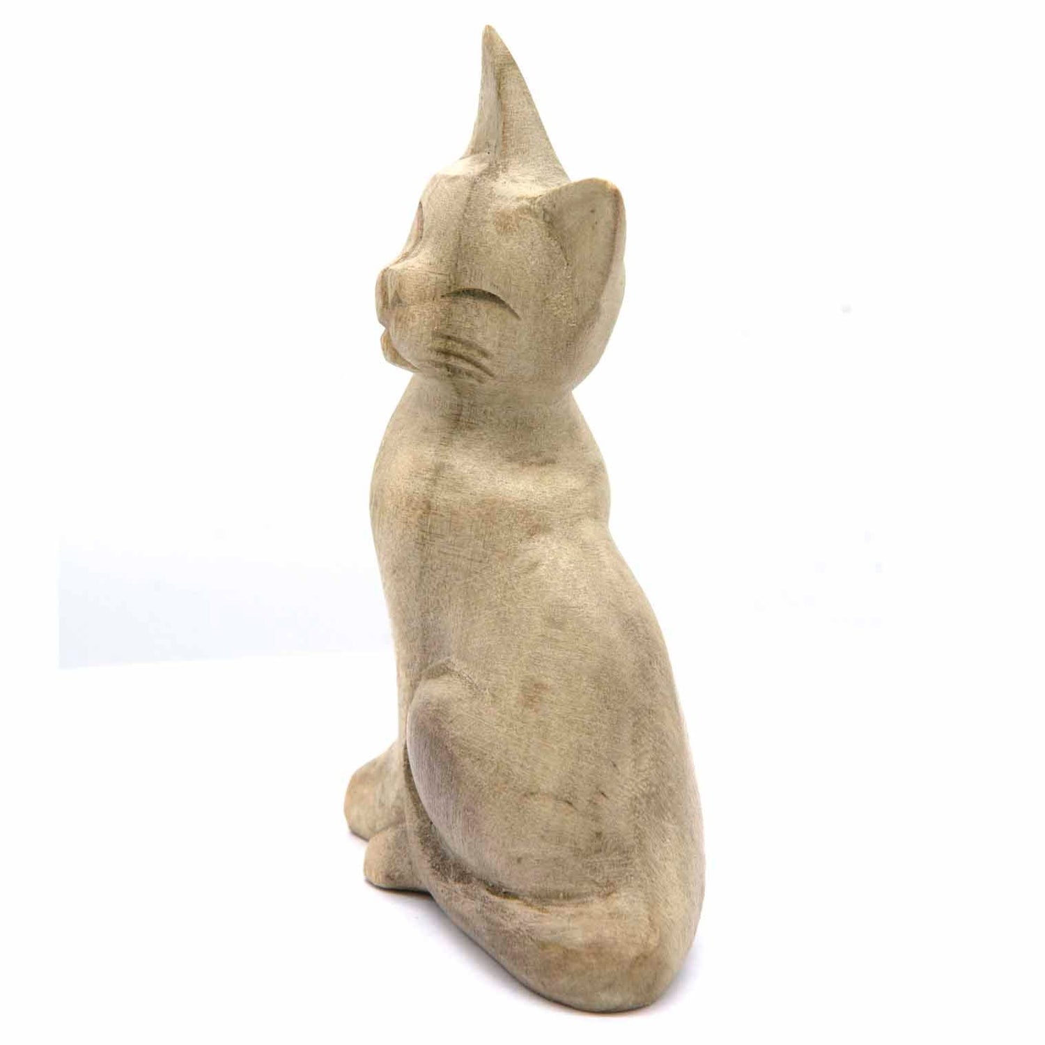 Hand-carved cat figurine in bleached wood, side view showing smooth rounded body, Indonesia