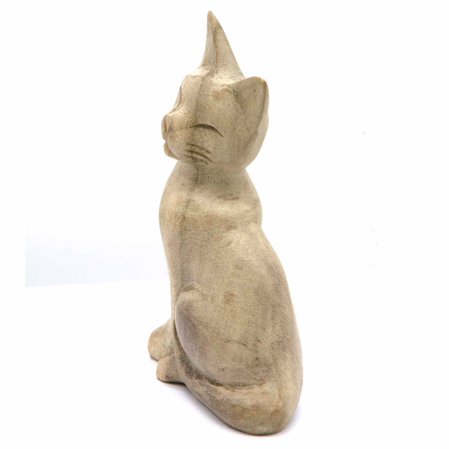 Hand-carved cat figurine in bleached wood, side view showing smooth rounded body, Indonesia