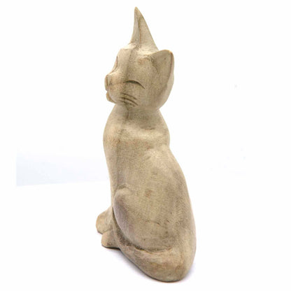 Hand-carved cat figurine in bleached wood, side view showing smooth rounded body, Indonesia