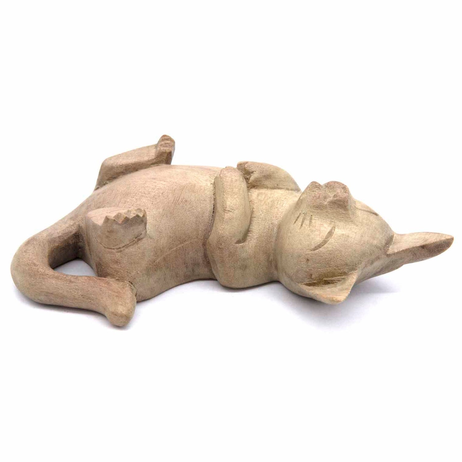 Hand-carved cat figurine lying on its back, legs in the air, bleached wood finish