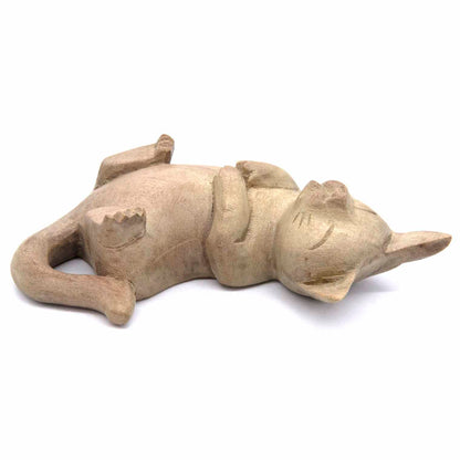 Hand-carved cat figurine lying on its back, legs in the air, bleached wood finish