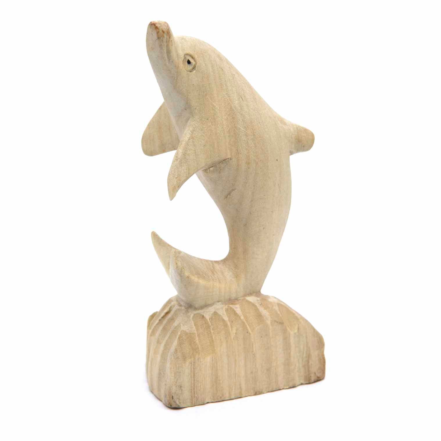 Pale wood dolphin carving arching from a carved wave base, three-quarter view, Indonesia