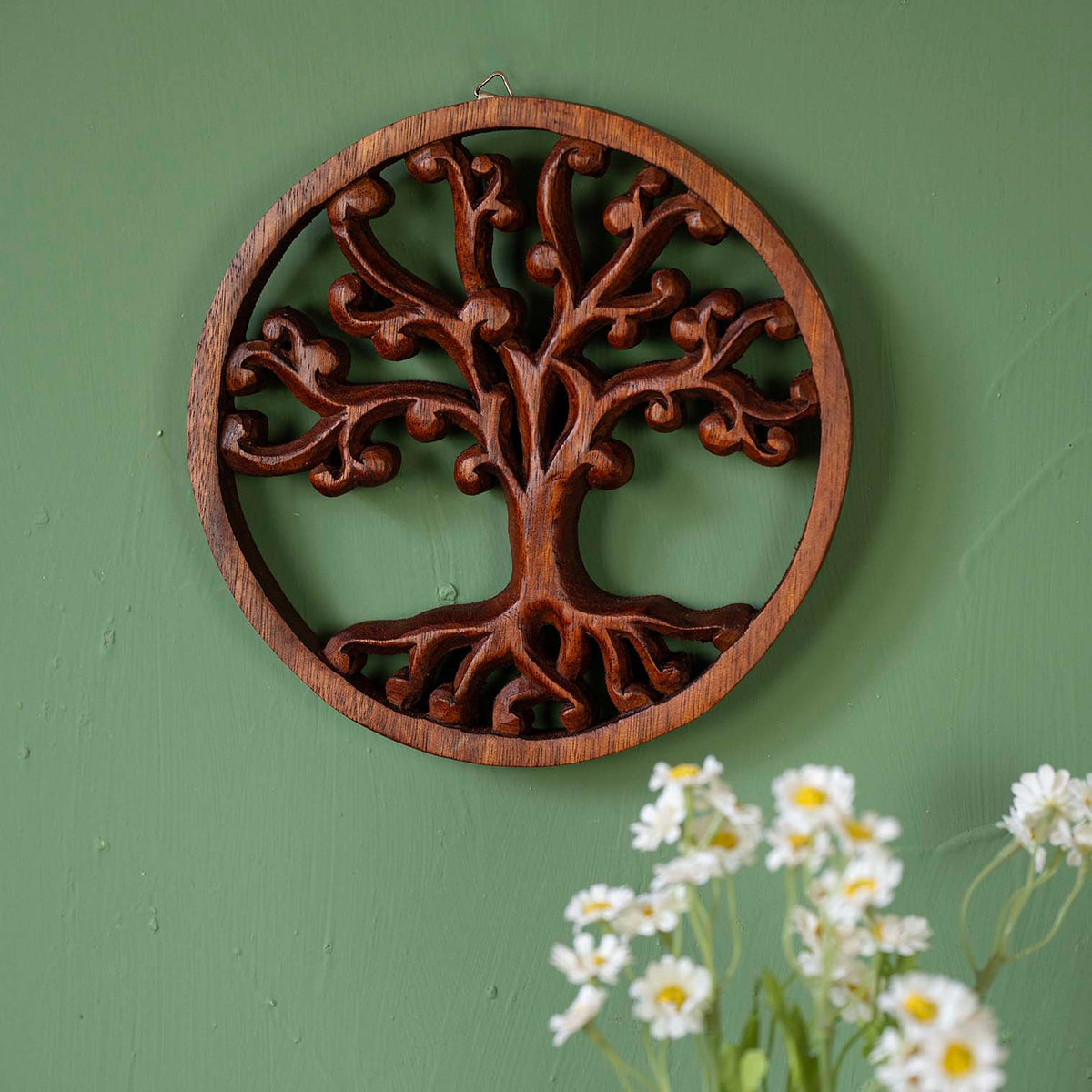 Circular carved wood plaque with Tree of Life design, scrolling branches and roots in warm brown relief within a turned ring frame
