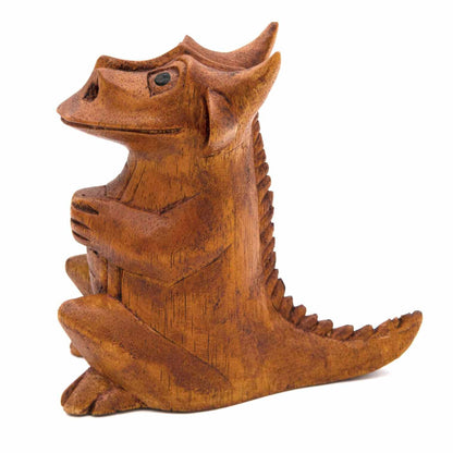 Carved dragon figurine, side view showing swept tail and ridged back, Indonesia