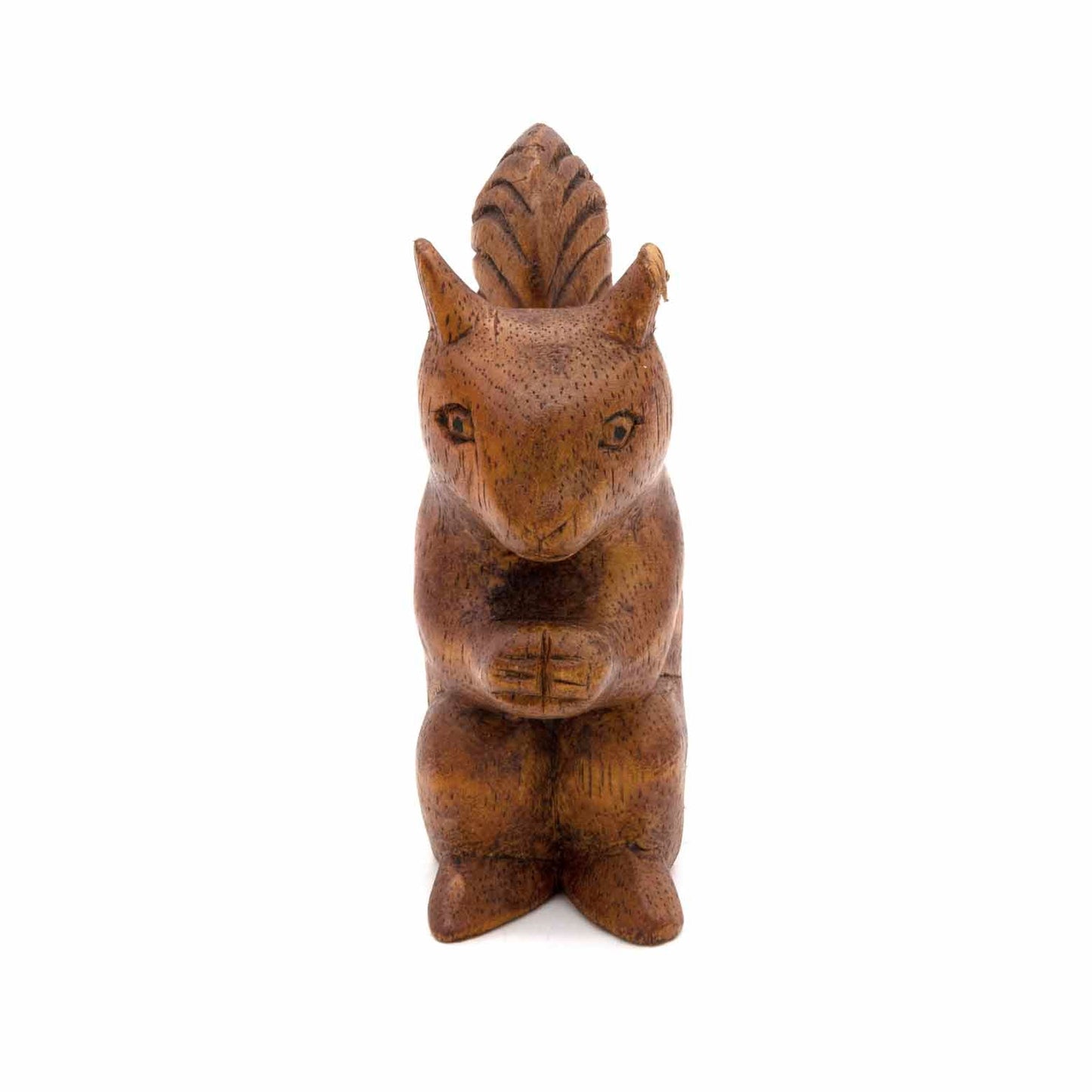 Hand-carved squirrel figurine, front view showing face and paws holding nut, warm wood