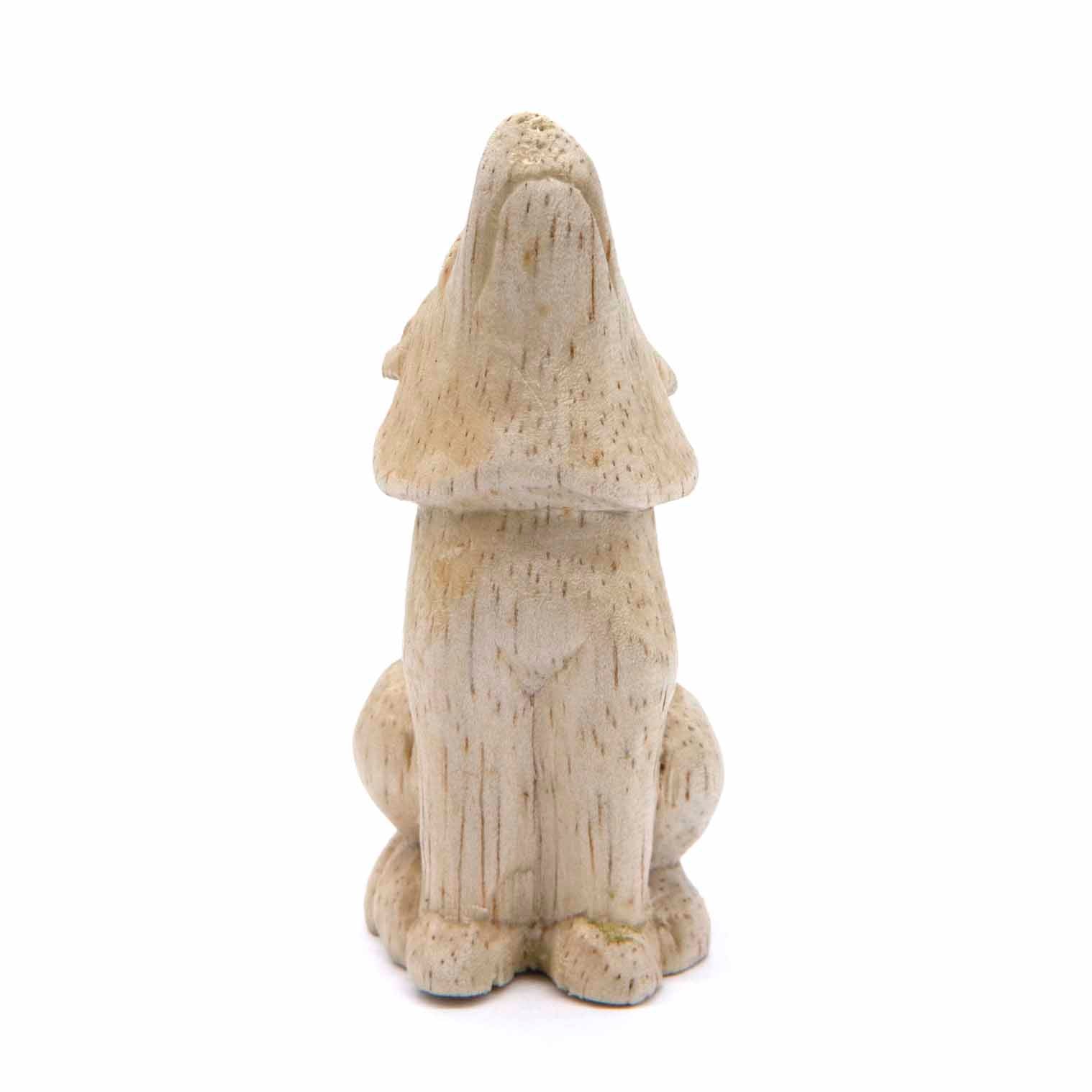 Small carved wolf figurine, rear view showing smooth pale wood body and ear detail, Indonesia
