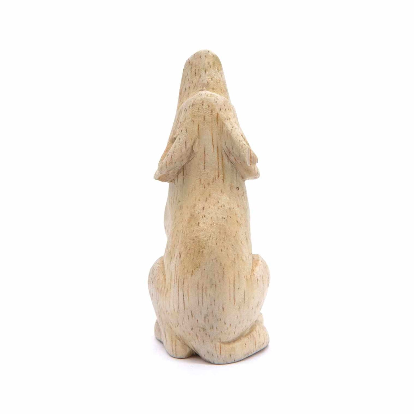 Small Indonesian wood wolf carving, side three-quarter view showing seated form and paws