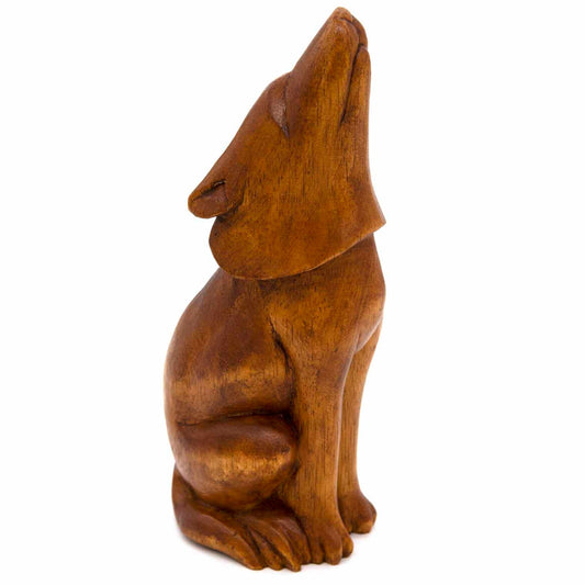 Large howling wolf wood carving, side view showing head thrown back and warm amber grain