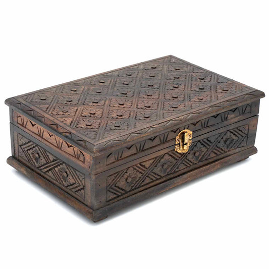 Three-quarter view of carved wooden jewellery box showing geometric floral pattern across lid and sides