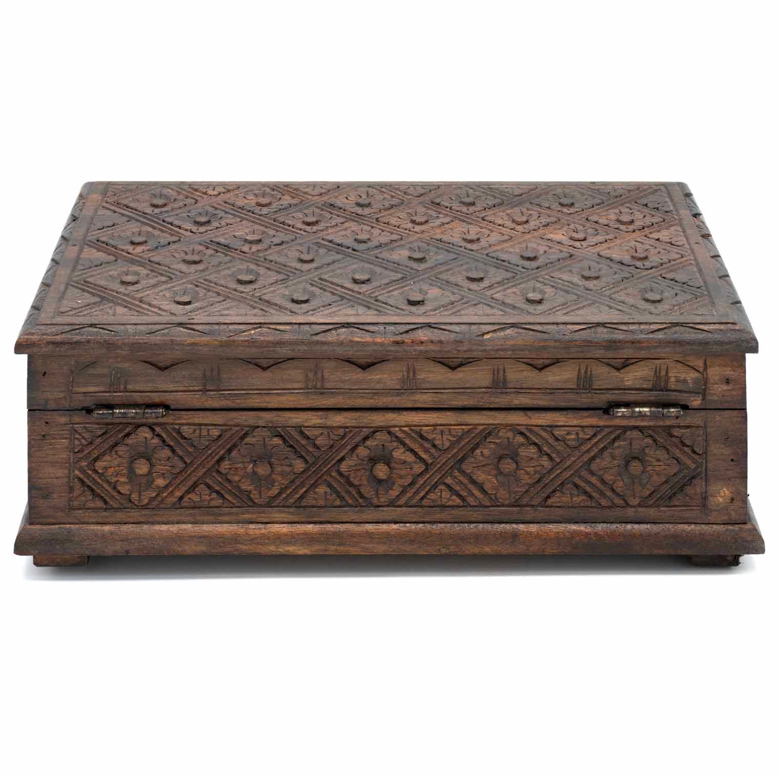 Rear view of carved wood jewellery box showing metal hinges and continuous diamond relief carving on back panel