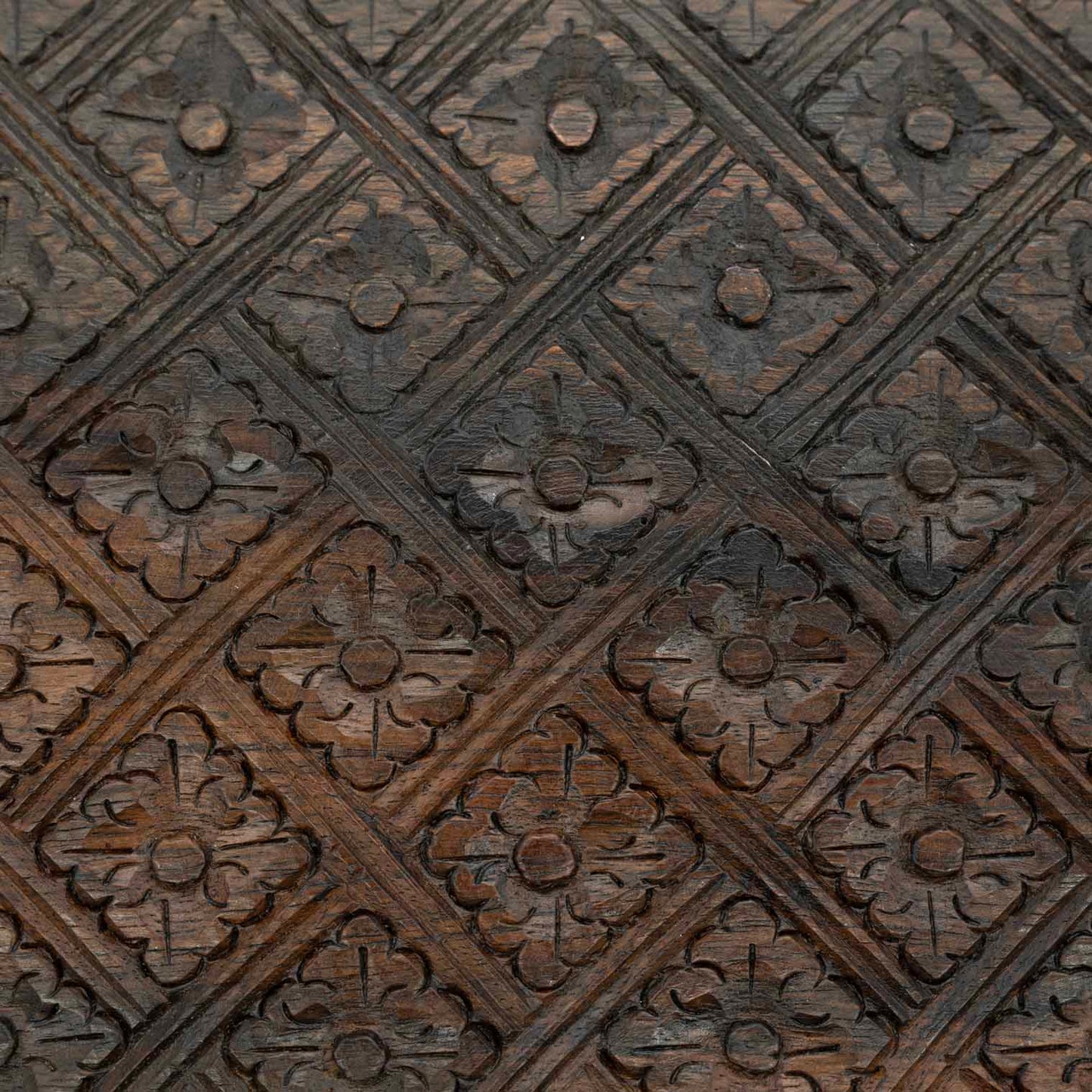 Macro detail of diamond-and-flower relief carving on the lid of the Indonesian wooden jewellery box