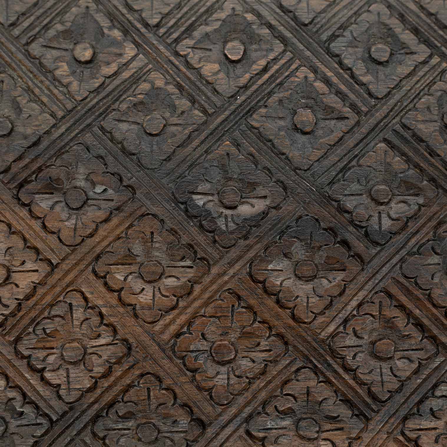 Macro detail of diamond-and-flower relief carving on the lid of the Indonesian wooden jewellery box