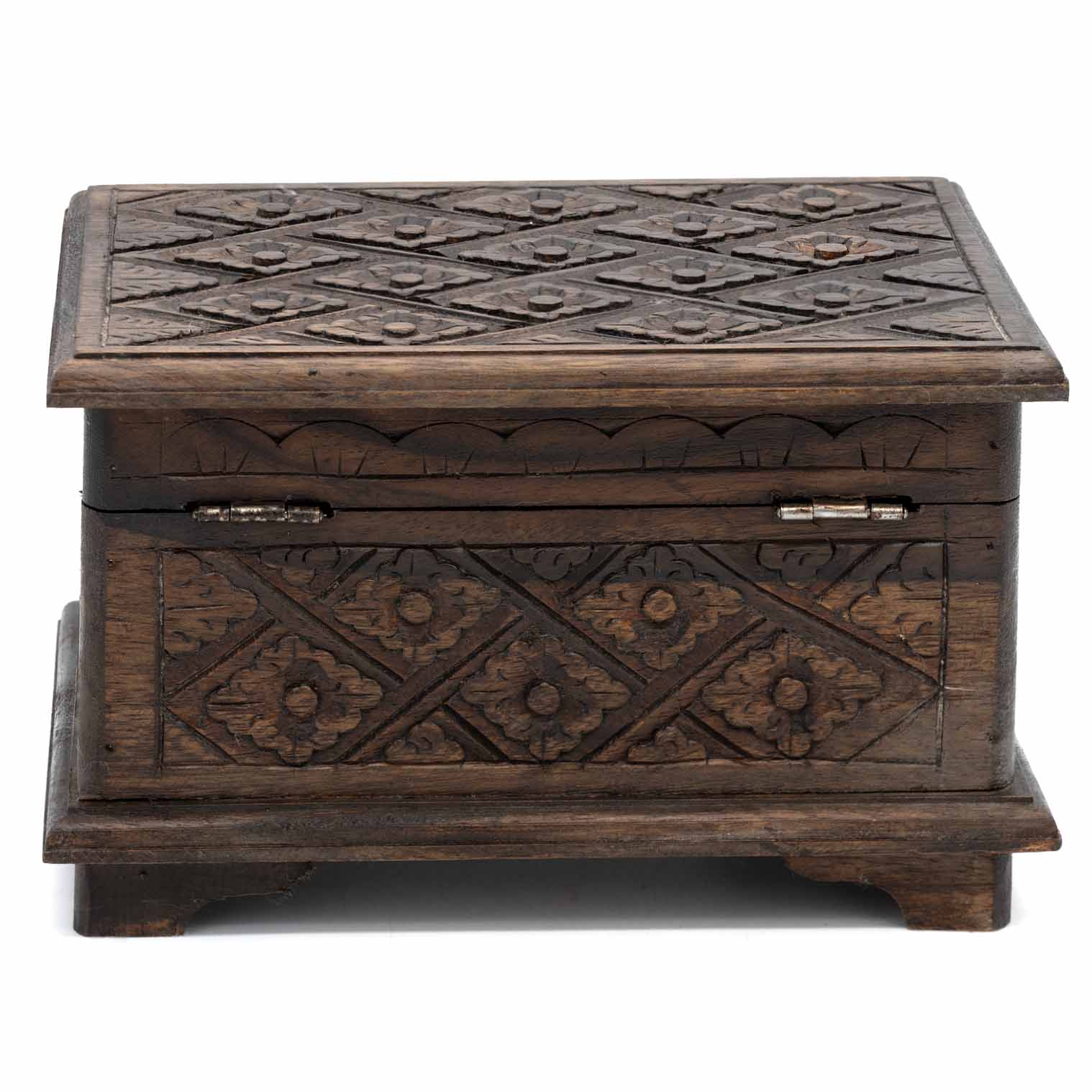 Side view of carved wood jewellery chest showing bracket feet, hinges and continuous geometric carving
