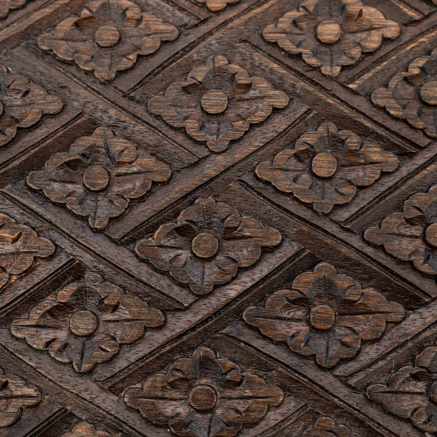 Macro detail of diamond-and-flower relief carving on the lid of the Indonesian wooden jewellery chest