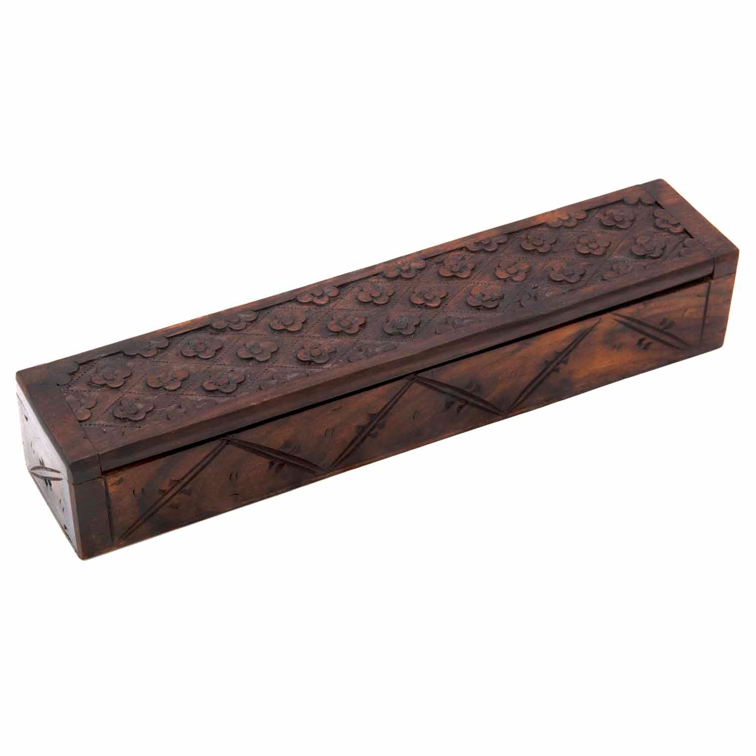 Long narrow carved wood box closed, three-quarter view showing flower-grid lid and lattice-carved sides, Indonesia