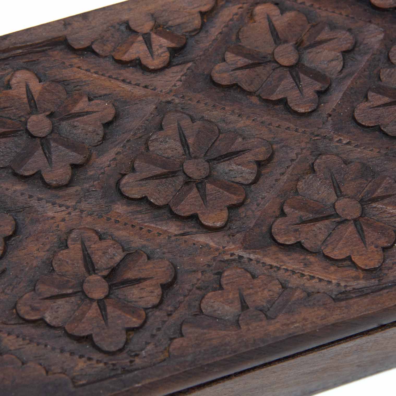 Close-up of hand-chisel flower relief carving on the lid of the Indonesian wooden playing card box