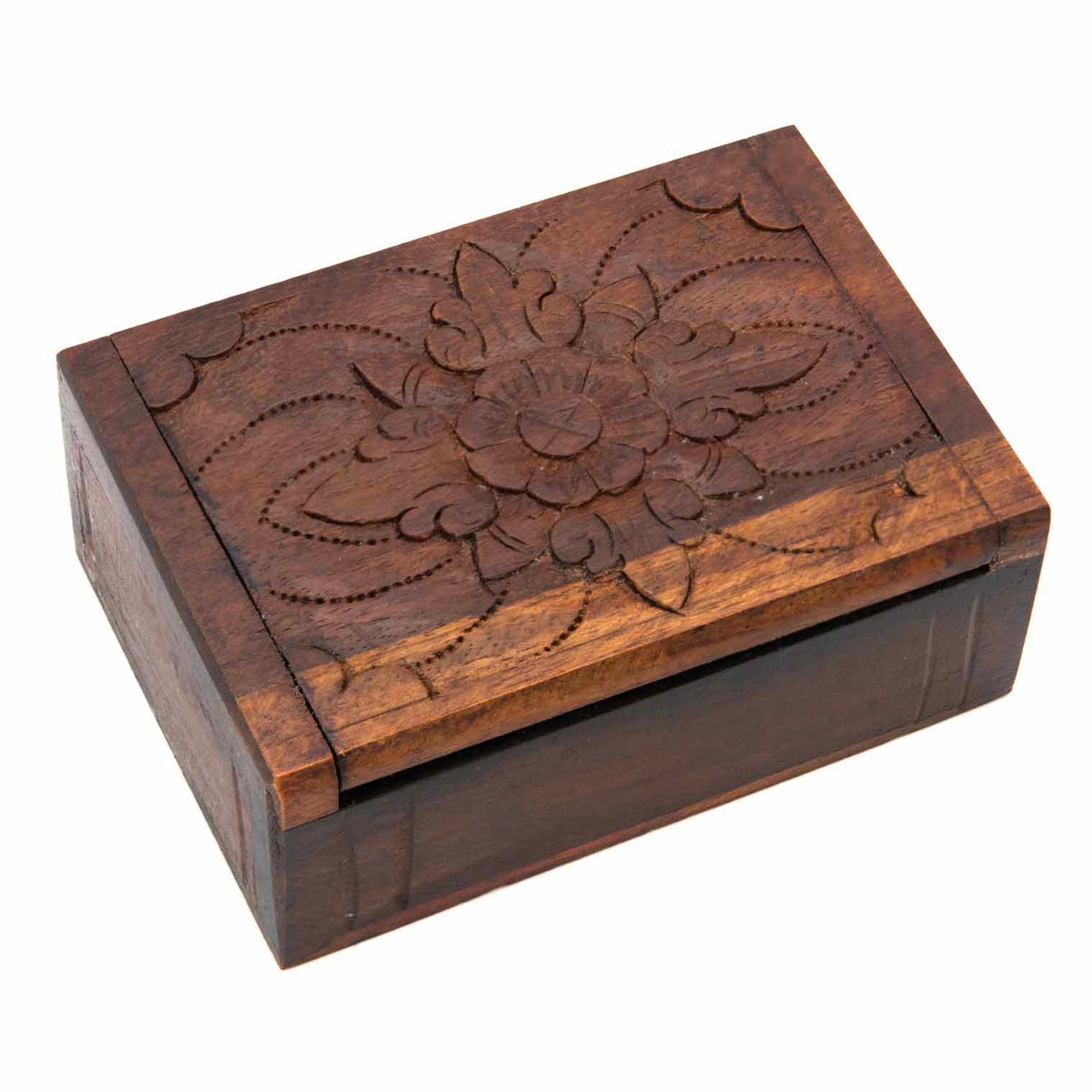 Three-quarter view of carved wooden card box closed, showing single central flower motif on lid, white background