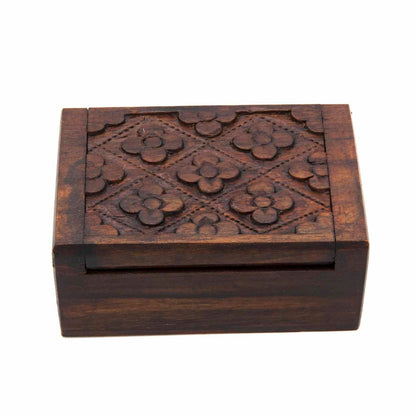Top-down view of mini carved wood box showing flower-and-diamond relief pattern across the full lid surface