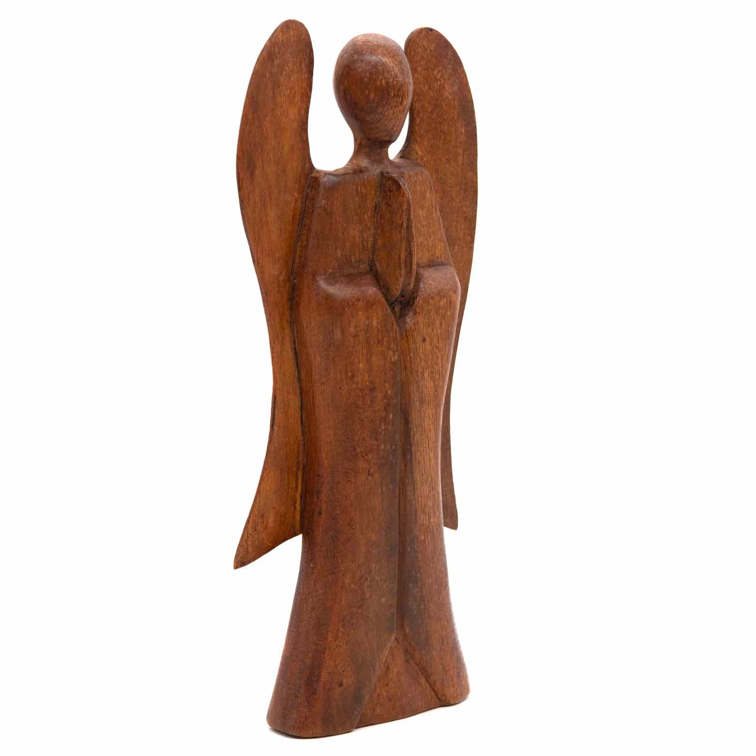 Three-quarter view of 30cm abstract wooden angel carving showing wing depth and grain, Indonesia