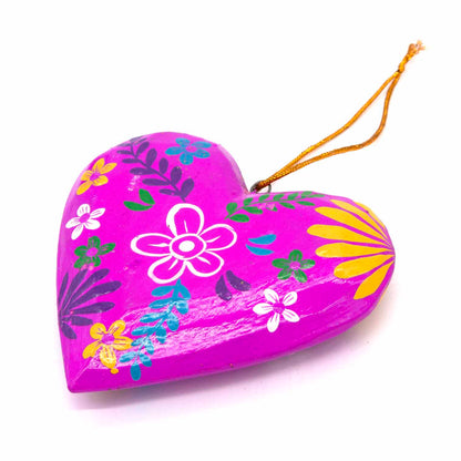 Magenta hand-painted wood heart, angled side view showing domed form and gold hanging cord, Bali Indonesia