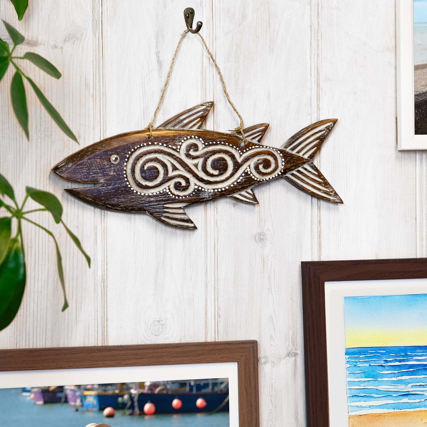 Hand-carved wooden fish plaque with flowing tribal-style relief carving, made by artisans in Bali, Indonesia
