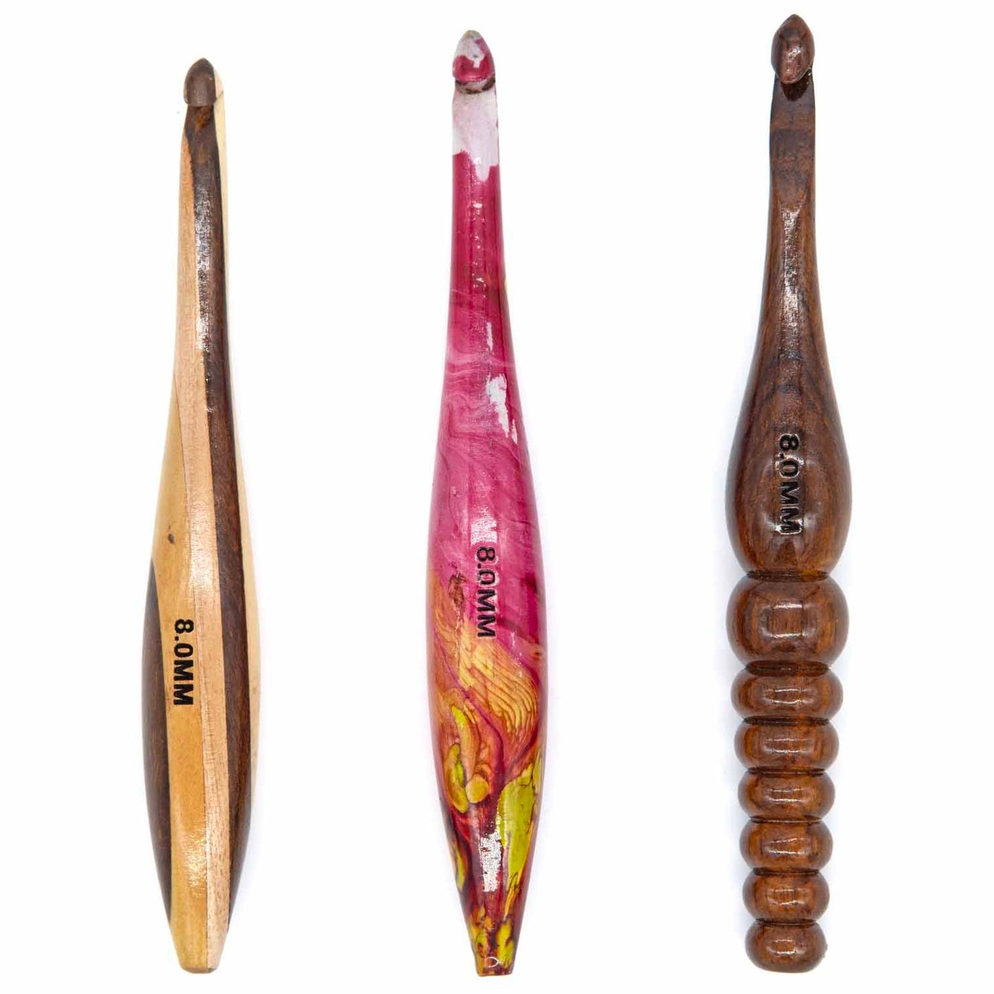 Three 8mm wooden crochet hooks side by side: two-tone flat, pink resin-inlay, and dark ringed turned handle