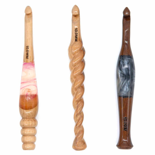 Three 10mm wooden crochet hooks: pale wood with pink resin inlay, twisted-rope turned handle, dark wood with grey resin inlay