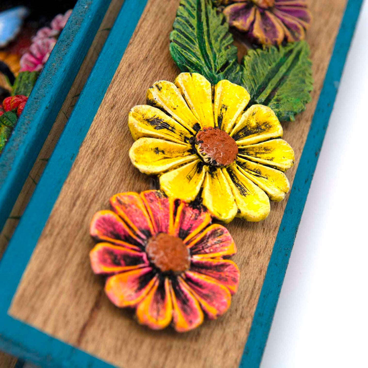 Close-up of inner door panel showing aged relief clay flowers in yellow and orange-red tones