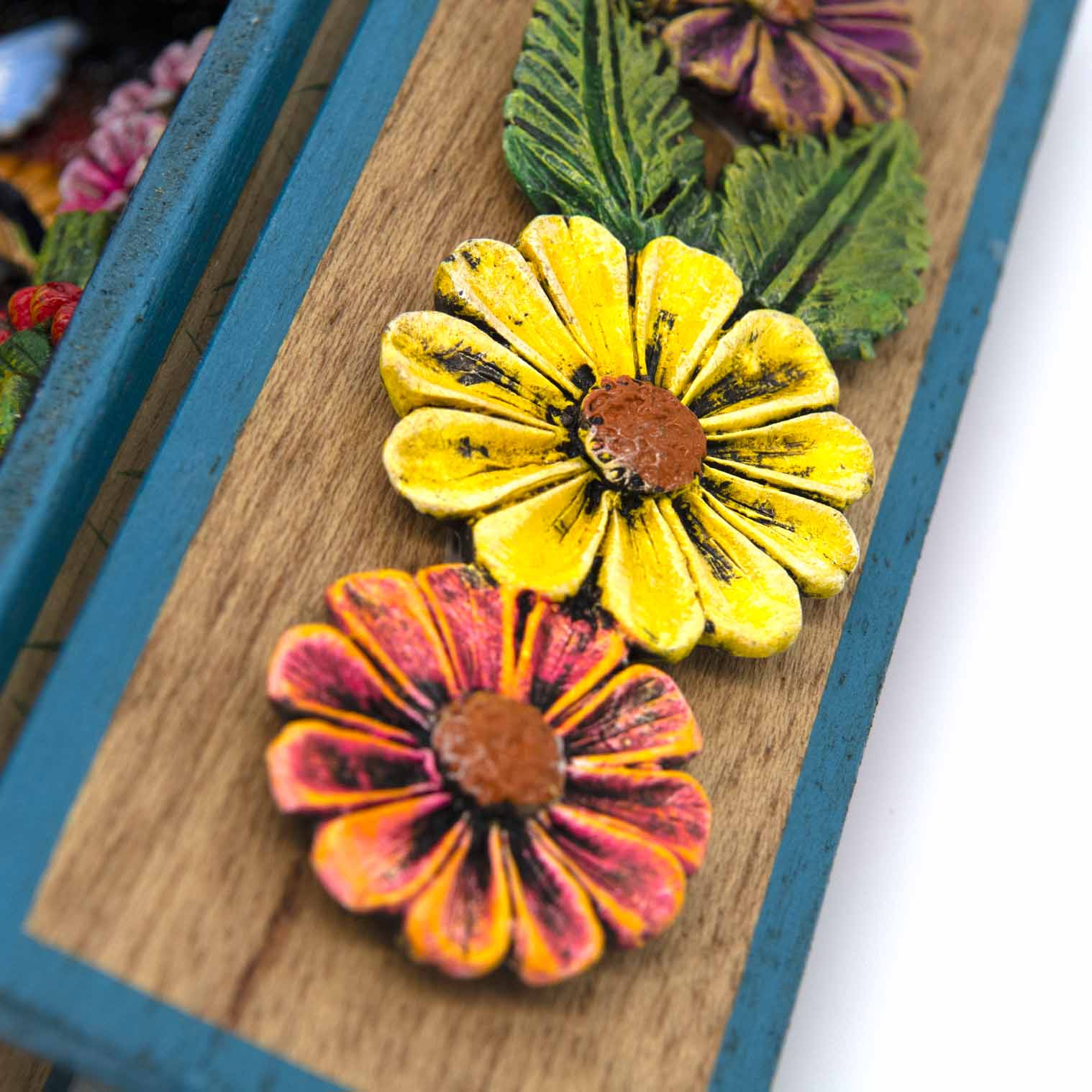 Close-up of inner door panel showing aged relief clay flowers in yellow and orange-red tones
