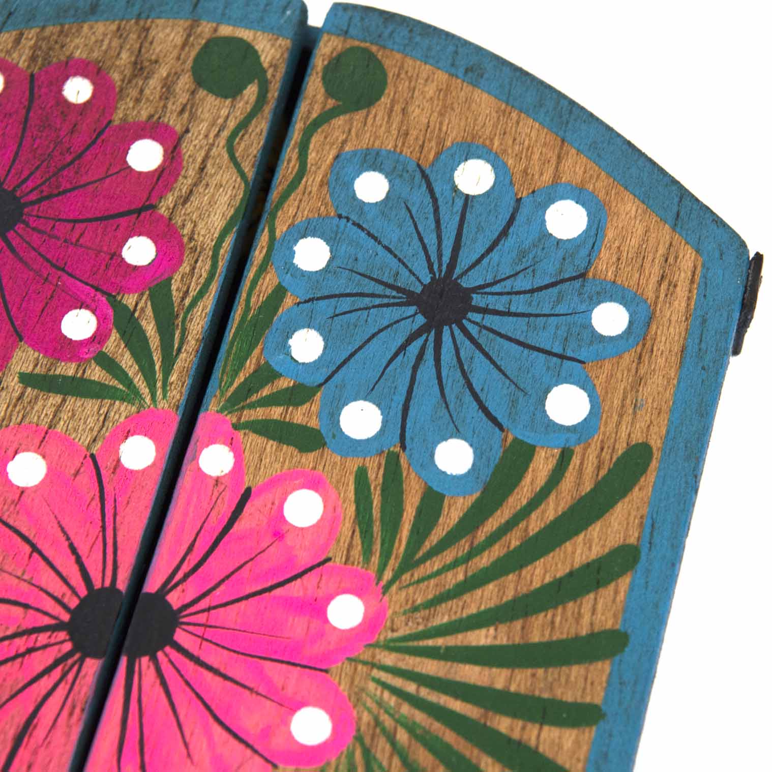 Close-up of upper door panels showing hand-painted pink and blue folk flowers on wood grain