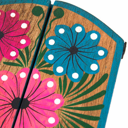 Close-up of upper door panels showing hand-painted pink and blue folk flowers on wood grain
