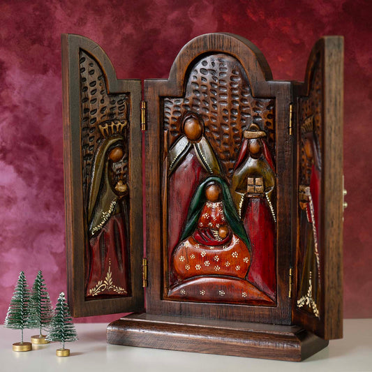 Cedar wood nativity triptych open at an angle, showing carved relief nativity scene in red and green, Peru, festive setting