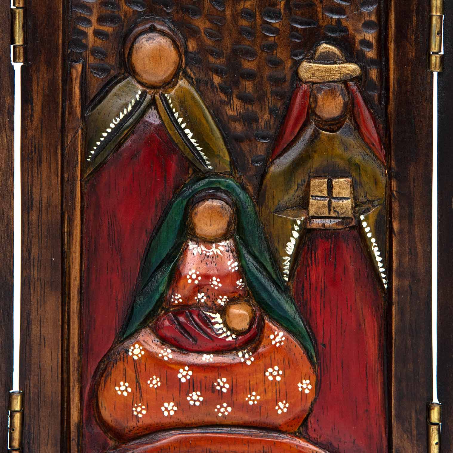 Close-up of central nativity panel showing carved Mary, Joseph and wise men in red, green and gold paint, Peru