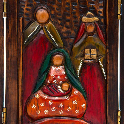 Close-up of central nativity panel showing carved Mary, Joseph and wise men in red, green and gold paint, Peru