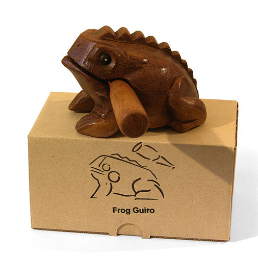 Frog guiro perched on printed kraft box showing side profile and carved detail